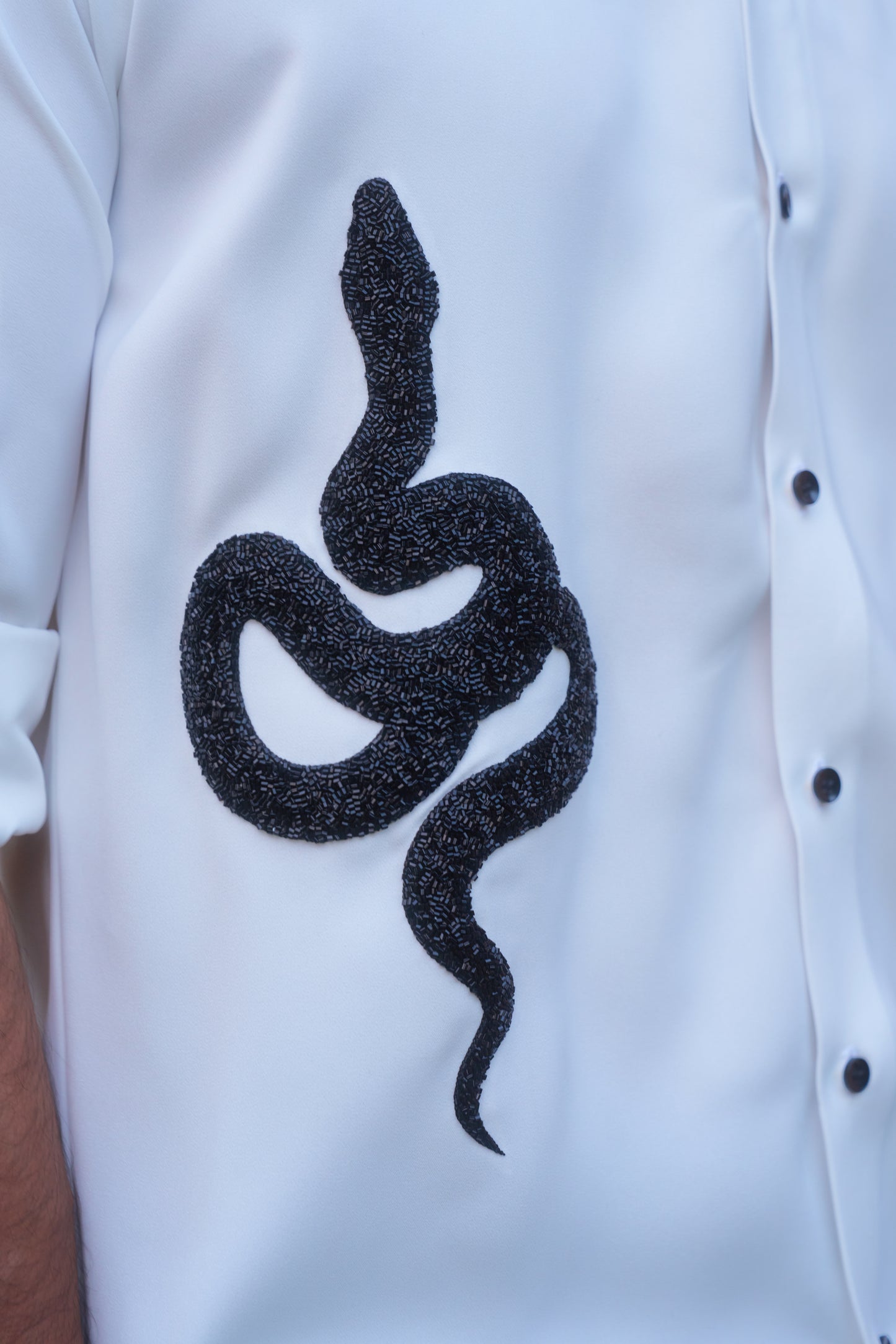 White shirt with a black snake hand embroidery design